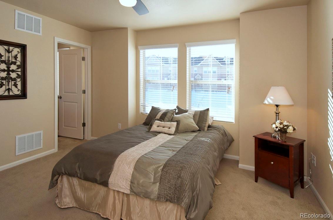 10296 Bellwether Lane Lone Tree, CO 80124 - Photo 17 of 29 a bed room with a bed and a lamp