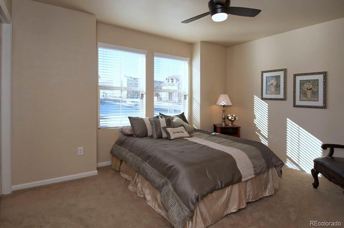10296 Bellwether Lane Lone Tree, CO 80124 - Photo 18 of 29 a spacious bedroom with a bed and a large window