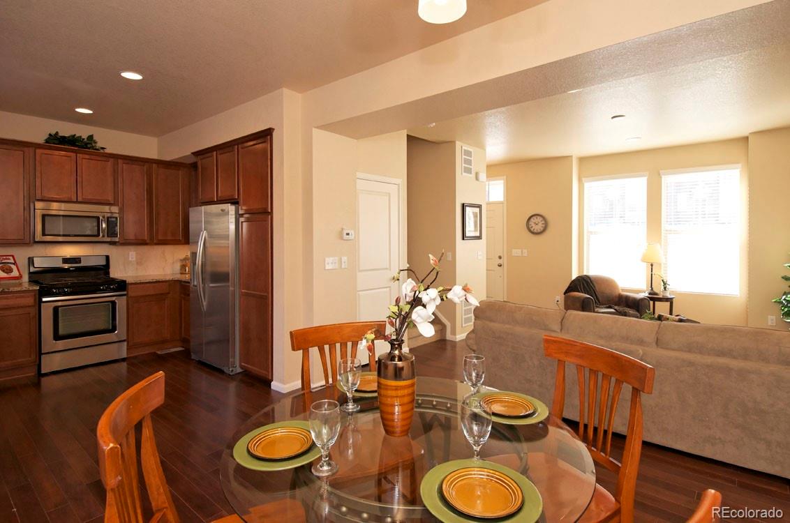 10296 Bellwether Lane Lone Tree, CO 80124 - Photo 8 of 29 a kitchen with sink refrigerator dining table and chairs
