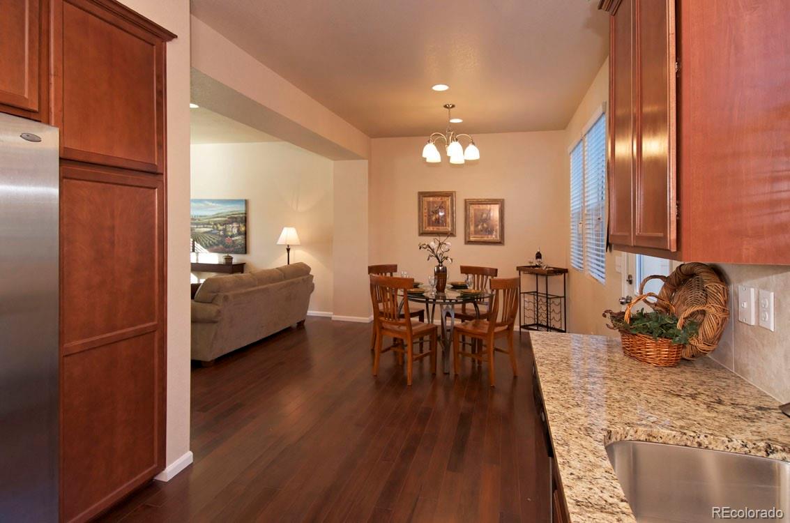 10296 Bellwether Lane Lone Tree, CO 80124 - Photo 9 of 29 a view of a dining room with furniture and wooden floor