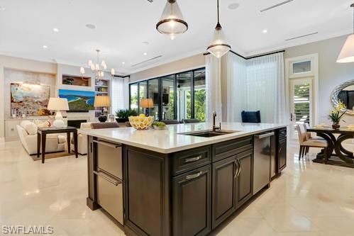 595 Regatta Road Naples, FL 34103 - Photo 11 of 40 Spacious open-concept interior featuring a large kitchen island with a built-in sink and stainless steel appliances