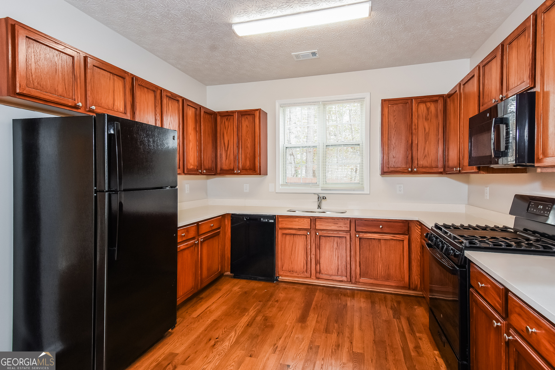 343 Alderman Trace Southwest Austell, GA 30168 - Photo 7 of 17 a kitchen with granite countertop stainless steel appliances a refrigerator cabinets and a sink