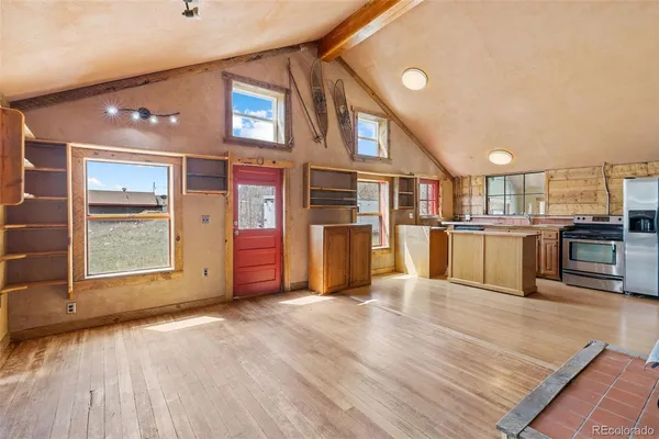 a view of a kitchen with stainless steel appliances wooden floor and a large window