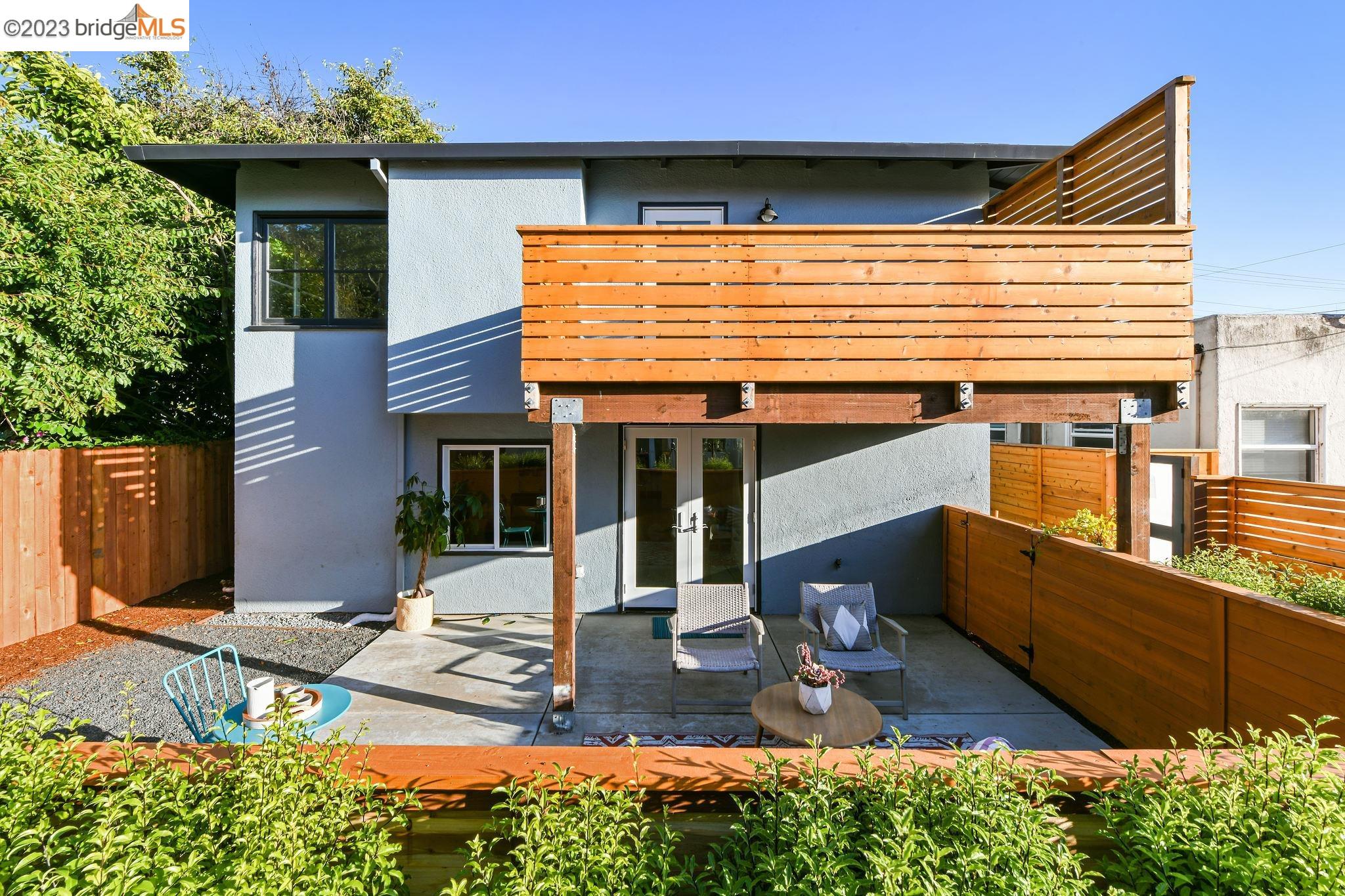 a view of a house with a large window and wooden fence