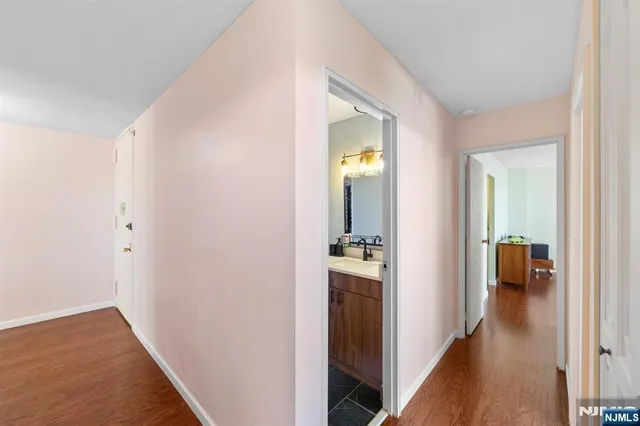 a view of a hallway with wooden floor and a living room