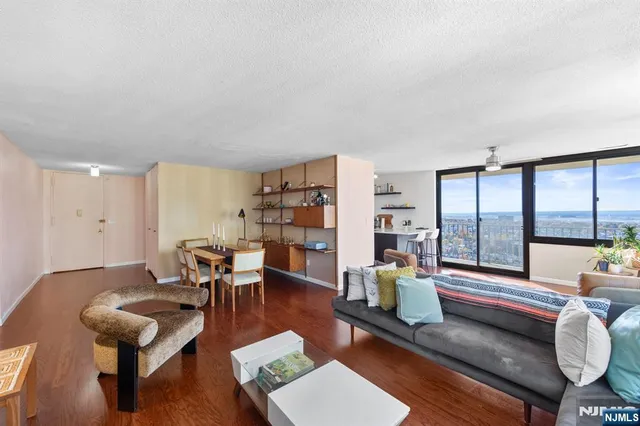 a living room with furniture flat screen tv and a large window