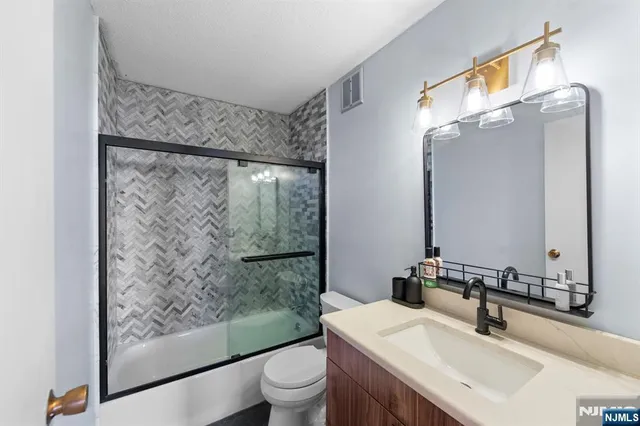 a bathroom with a sink mirror toilet and shower