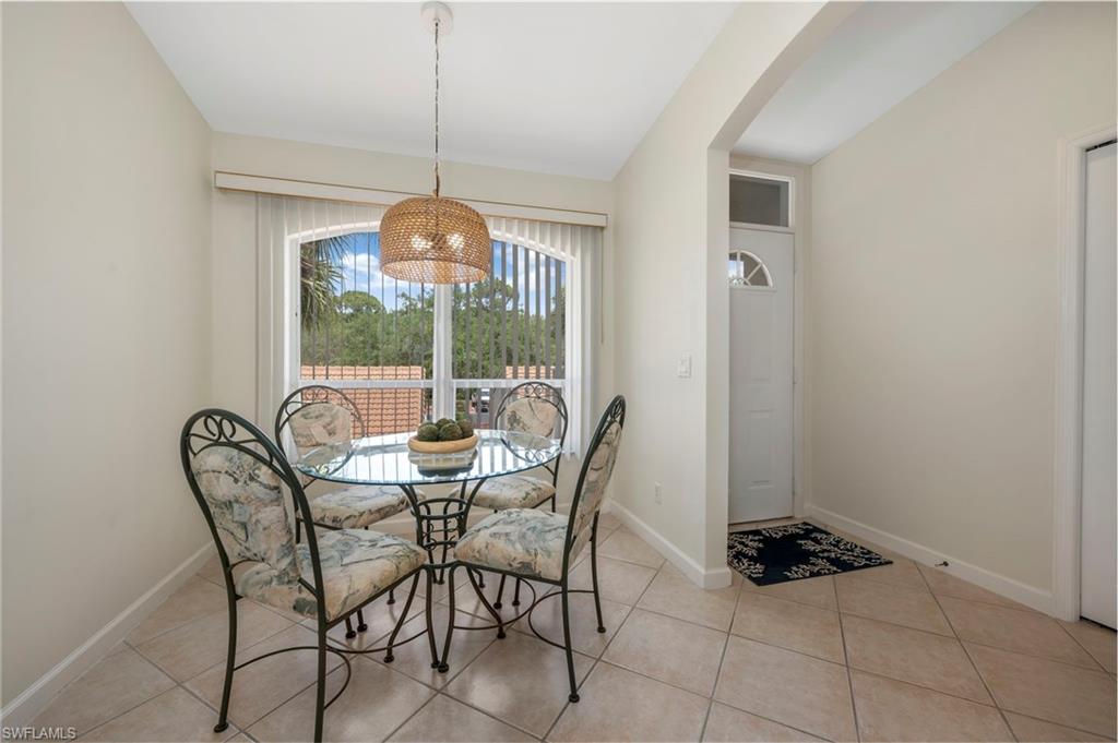 14530 Red Fox Run, Unit 204 Naples, FL 34110 - Photo 3 of 18 a dining room with furniture and a floor to ceiling window