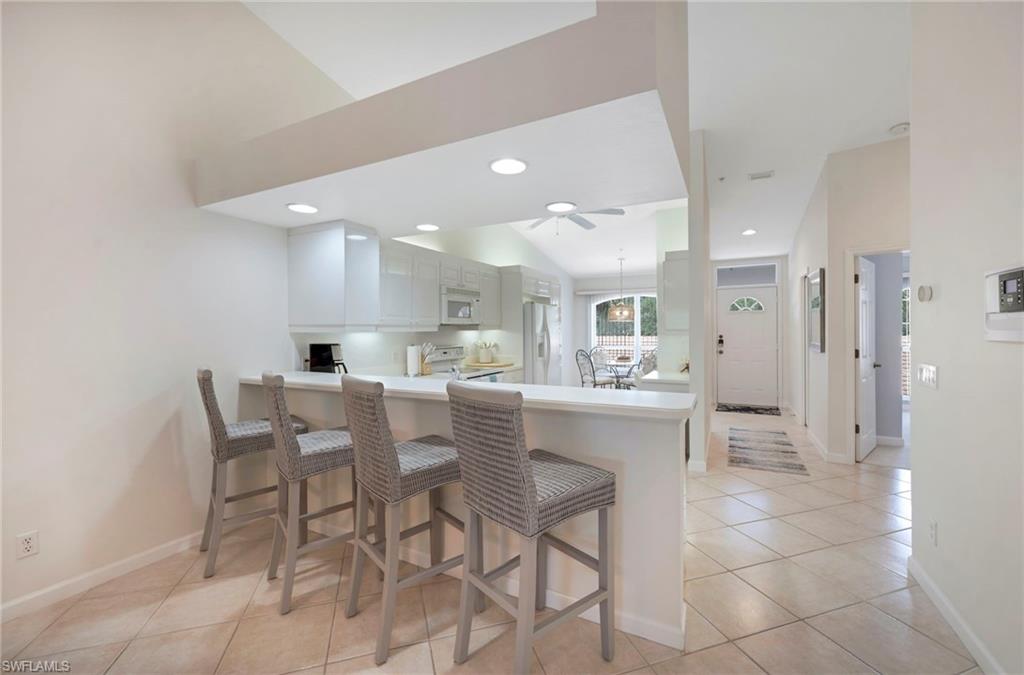 14530 Red Fox Run, Unit 204 Naples, FL 34110 - Photo 4 of 18 a kitchen with a dining table chairs and white cabinets