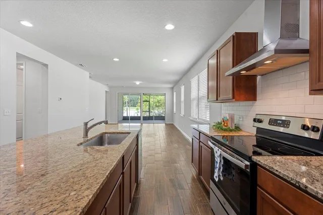 a kitchen with stainless steel appliances granite countertop a sink a stove top oven a counter space and cabinets