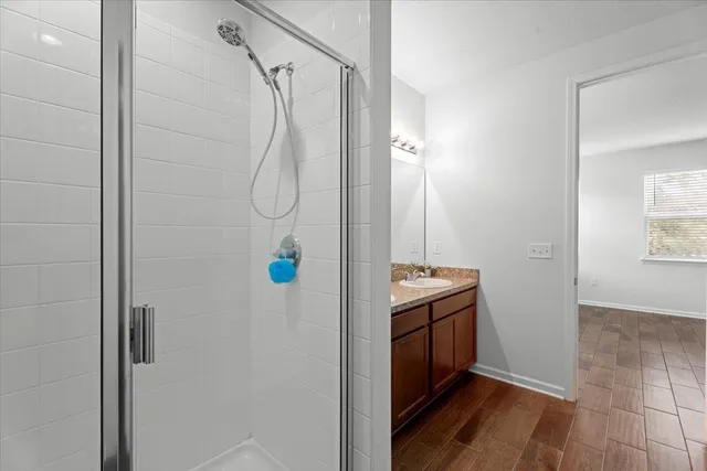 a bathroom with a granite countertop shower and a sink