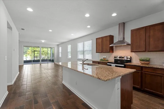 a kitchen with stainless steel appliances granite countertop a stove a sink a refrigerator and a microwave