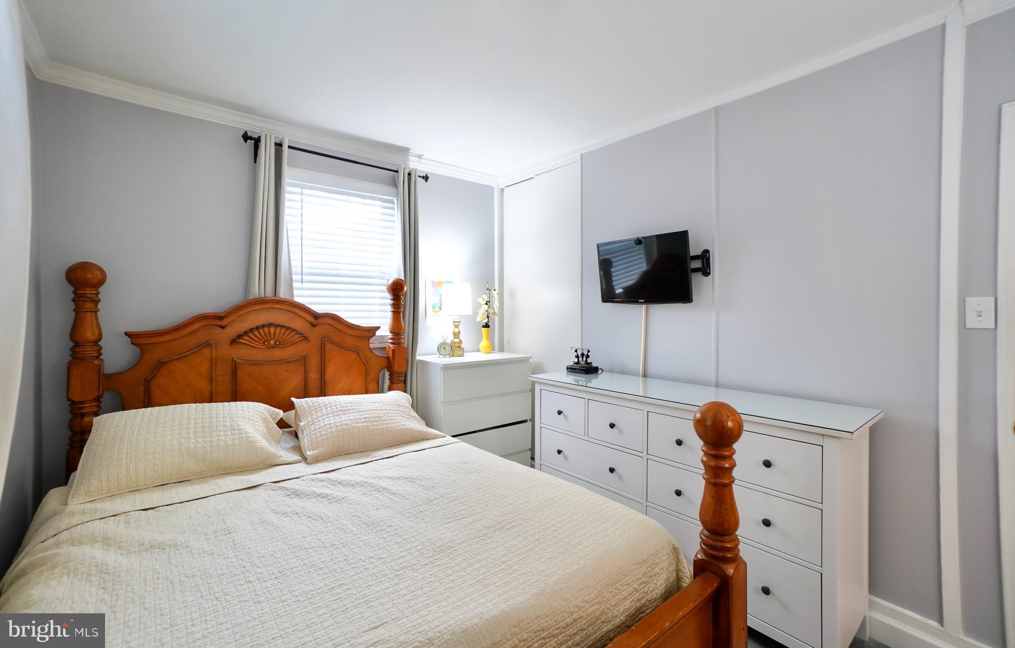 7767 Muncy Road Landover, MD 20785 - Photo 22 of 27 a bedroom with a bed and a flat tv screen on the dresser