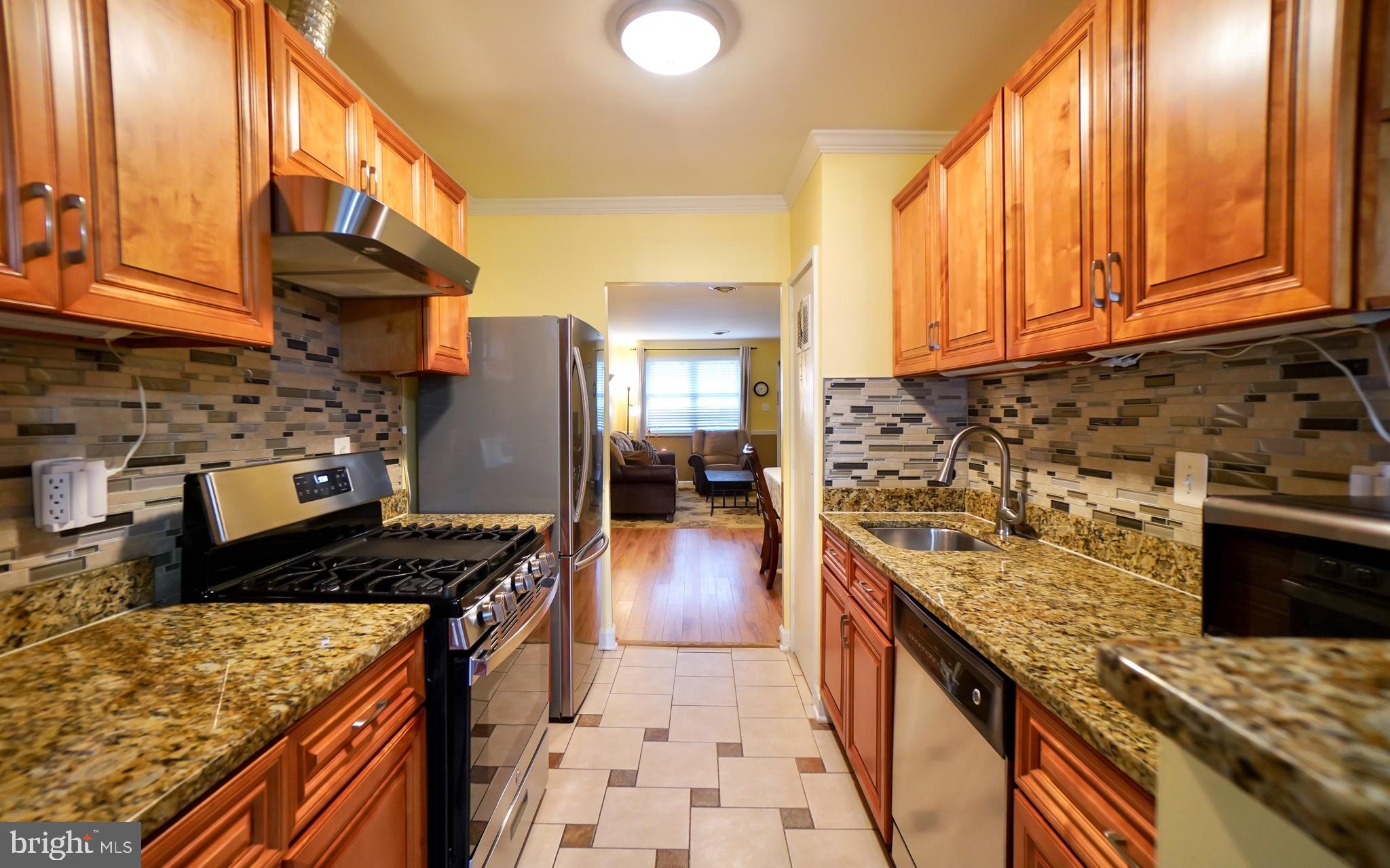 7767 Muncy Road Landover, MD 20785 - Photo 8 of 27 a kitchen with stainless steel appliances granite countertop a stove top oven a sink dishwasher and cabinets with wooden floor