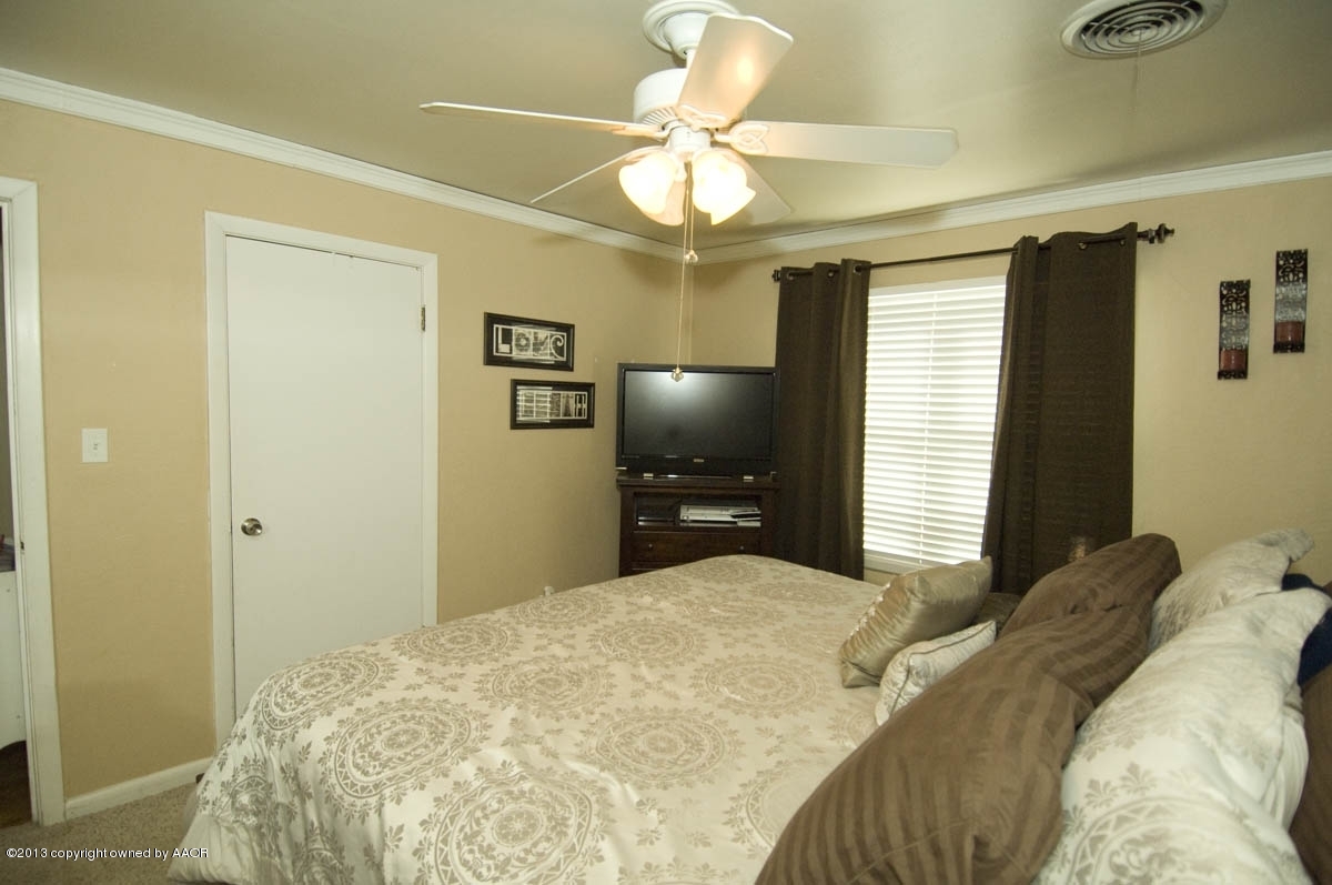 4227 South Jackson Street Amarillo, TX 79110 - Photo 14 of 23 a bedroom with a bed and a chandelier