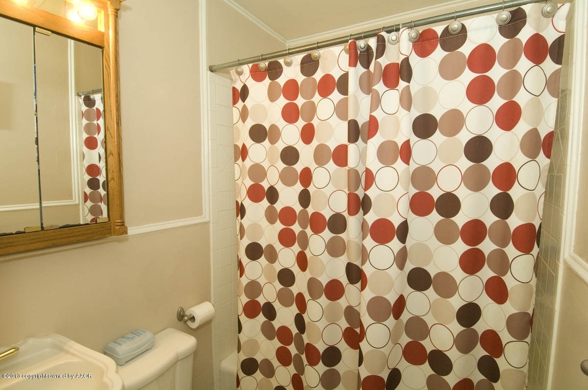 4227 South Jackson Street Amarillo, TX 79110 - Photo 15 of 23 a bathroom with a bathtub and a shower curtain