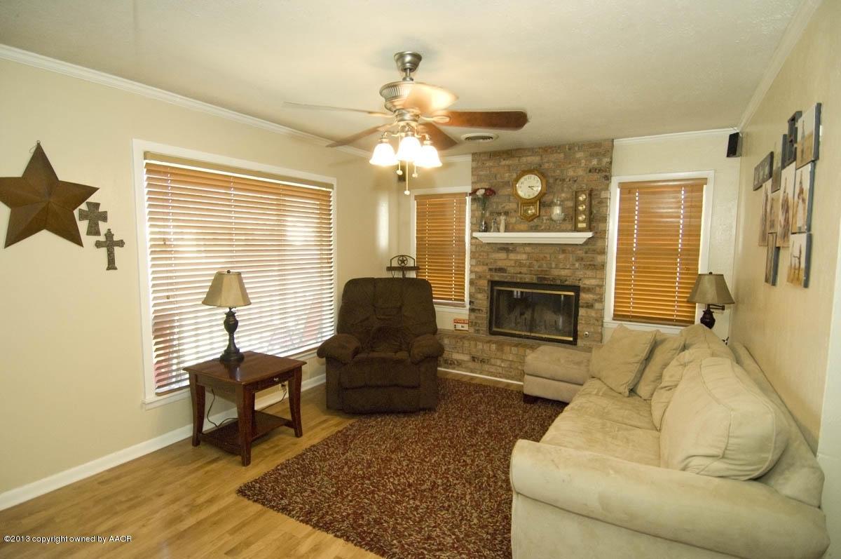4227 South Jackson Street Amarillo, TX 79110 - Photo 4 of 23 a living room with furniture a chandelier and a fireplace