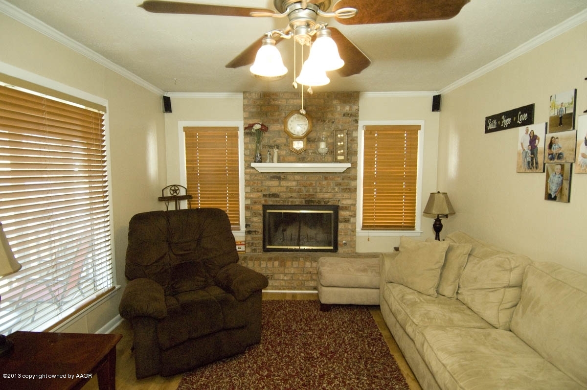 4227 South Jackson Street Amarillo, TX 79110 - Photo 5 of 23 a living room with furniture a fireplace and a chandelier