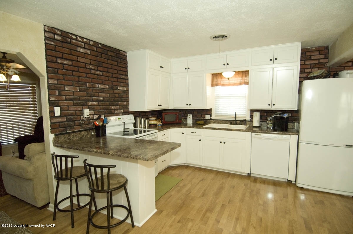 4227 South Jackson Street Amarillo, TX 79110 - Photo 8 of 23 a kitchen with stainless steel appliances granite countertop a stove a sink dishwasher and a refrigerator with wooden floor