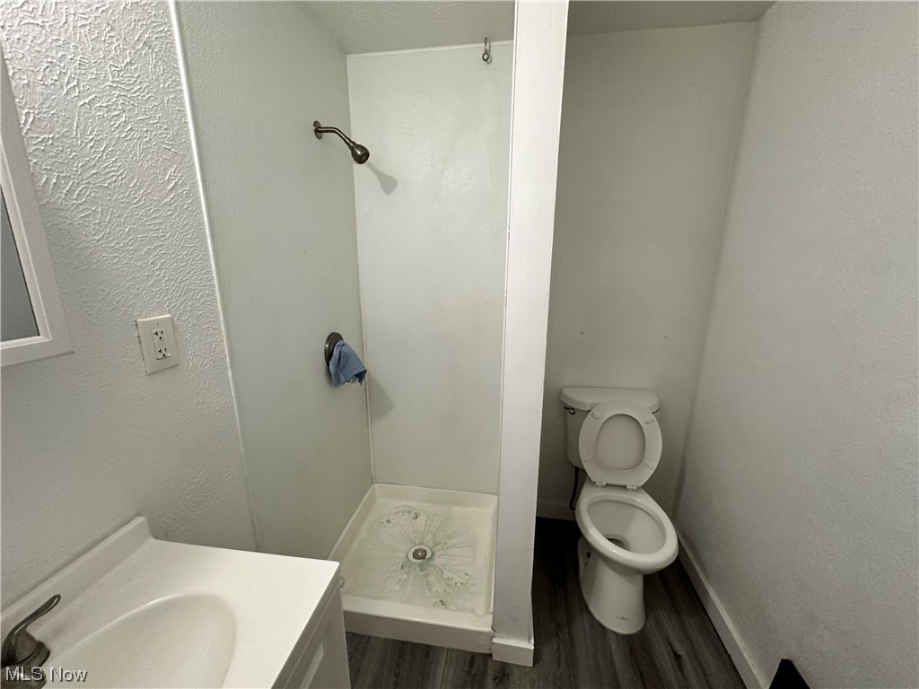 6734 Ottawa Road Cleveland, OH 44105 - Photo 14 of 31 Bathroom with walk in shower, toilet, hardwood / wood-style floors, and vanity