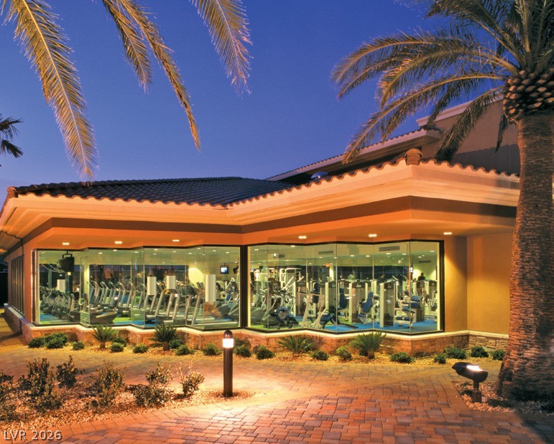 87 Tall Ruff Drive Las Vegas, NV 89148 - Photo 11 of 71 A well-equipped fitness center offers residents convenient access to exercise facilities, illuminated at twilight.