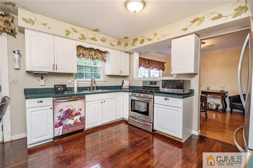 3 Sun Hollow Road Howell, NJ 07731 - Photo 8 of 36 a kitchen with granite countertop a stove top oven sink and cabinets