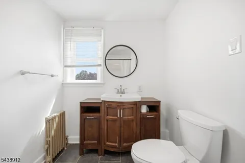a bathroom with a toilet a sink and a mirror