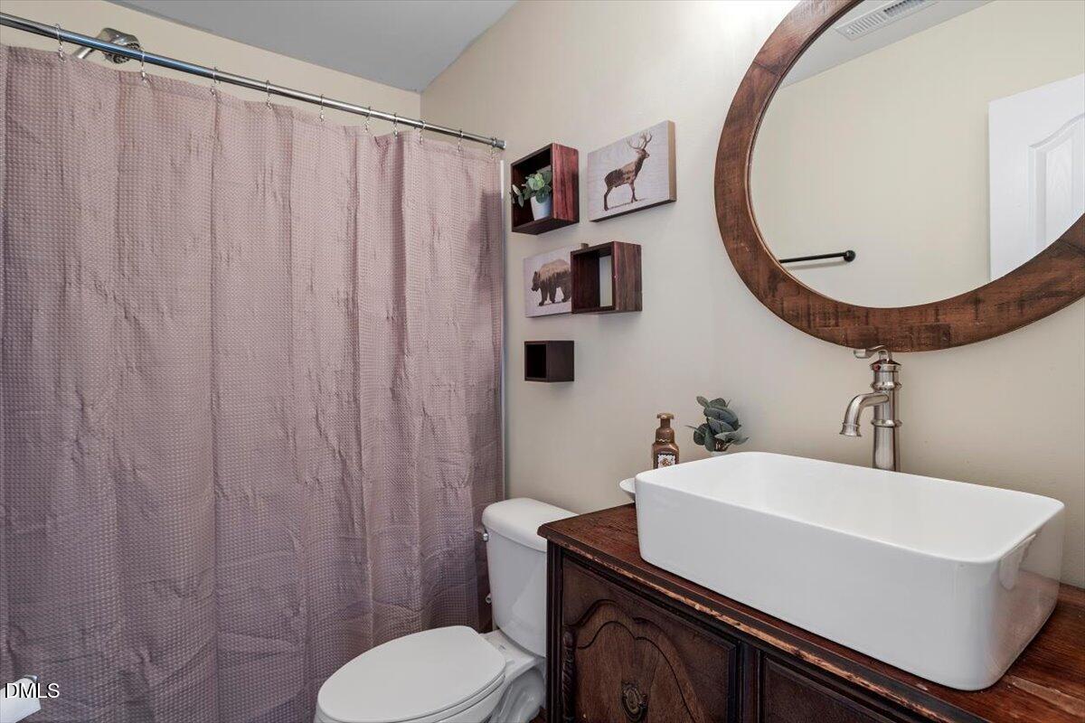 205 Battery Way Bunnlevel, NC 28323 - Photo 23 of 37 a bathroom with a sink a mirror and a toilet