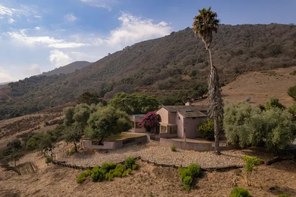 a view of a dry yard with mountains in the background