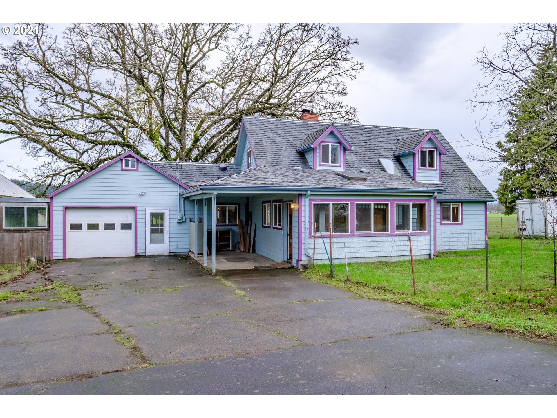 a front view of a house with a garden and trees