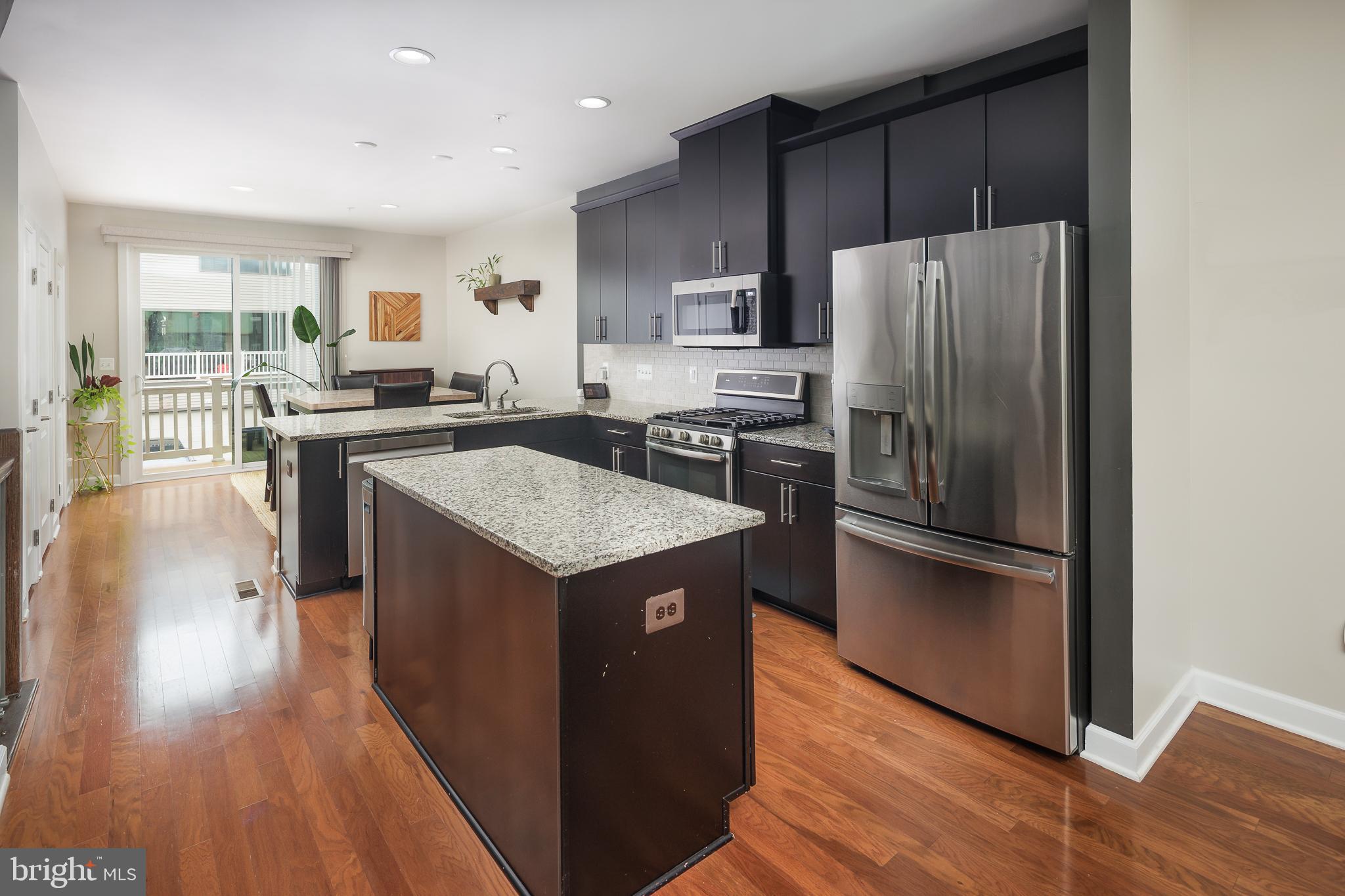 22355 Exe Square Ashburn, VA 20148 - Photo 8 of 65 a kitchen with wooden cabinets and stainless steel appliances
