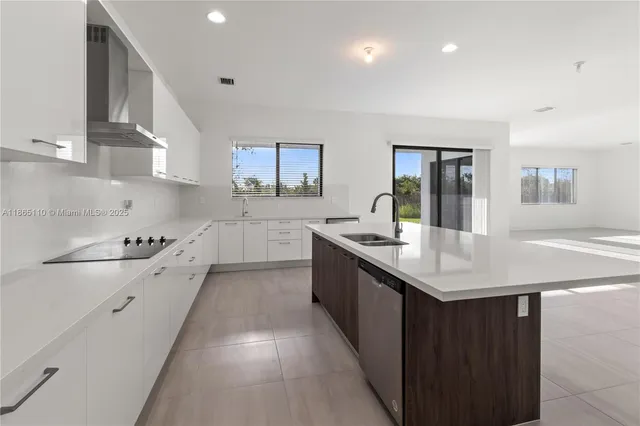 a kitchen with a sink a refrigerator and cabinets