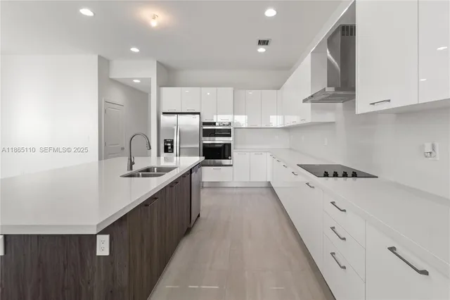 a kitchen with a sink a refrigerator and cabinets