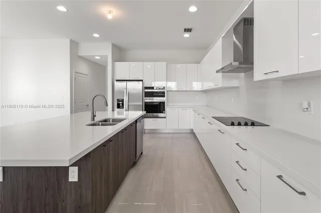 a kitchen with stainless steel appliances kitchen island a refrigerator sink and cabinets
