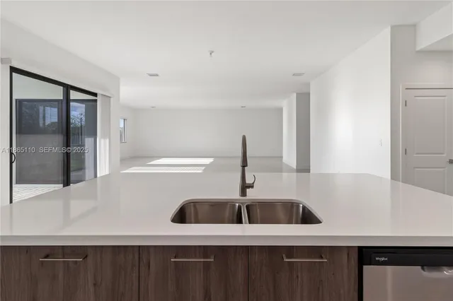 a kitchen with stainless steel appliances kitchen island a refrigerator sink and cabinets