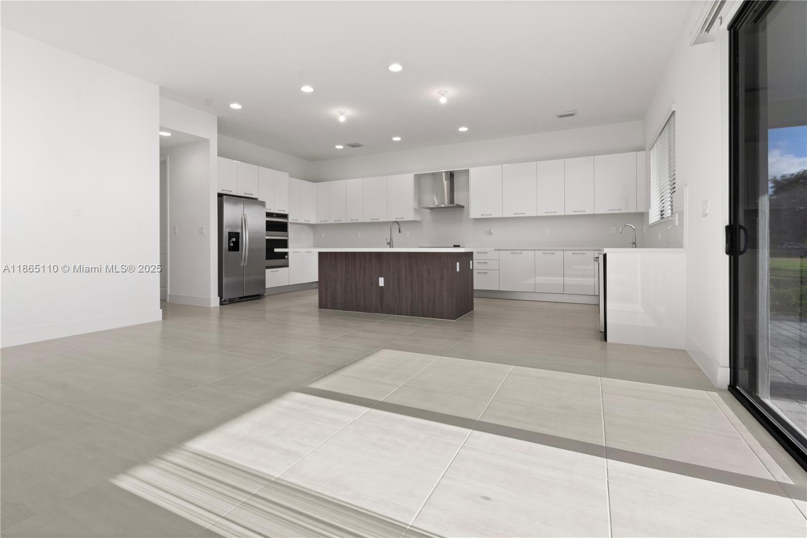 2391 Southwest 123rd Terrace Davie, FL 33325 - Photo 7 of 39 a large white kitchen with kitchen island a sink a stove and a refrigerator