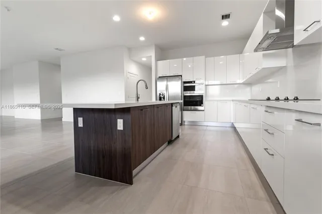 a kitchen with stainless steel appliances a sink a stove top oven a counter space and cabinets