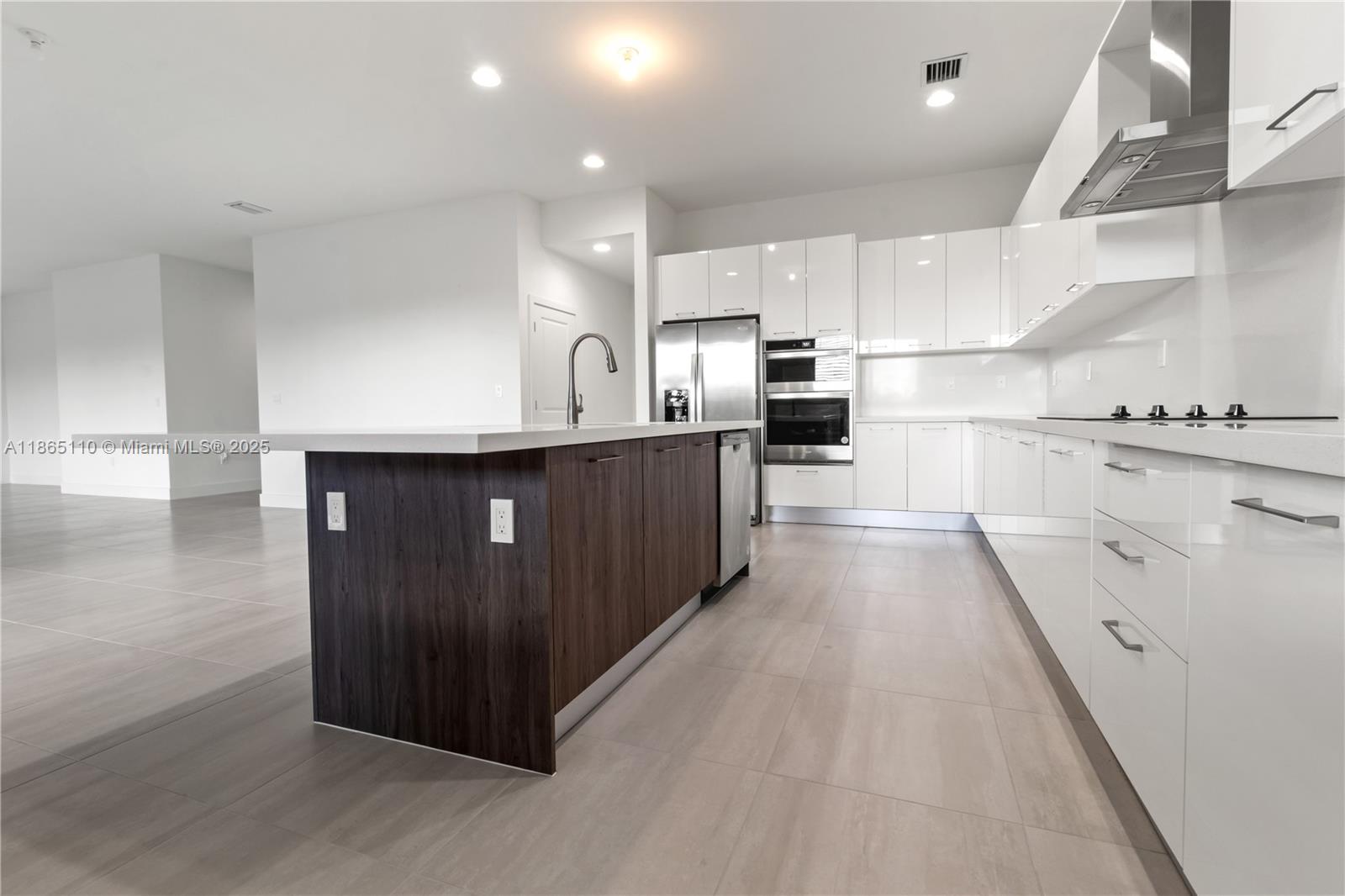 2391 Southwest 123rd Terrace Davie, FL 33325 - Photo 9 of 39 a kitchen with stainless steel appliances a sink a stove top oven a counter space and cabinets