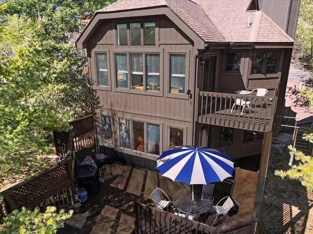 a large kitchen with granite countertop a stove a sink a refrigerator and white cabinets with wooden floor