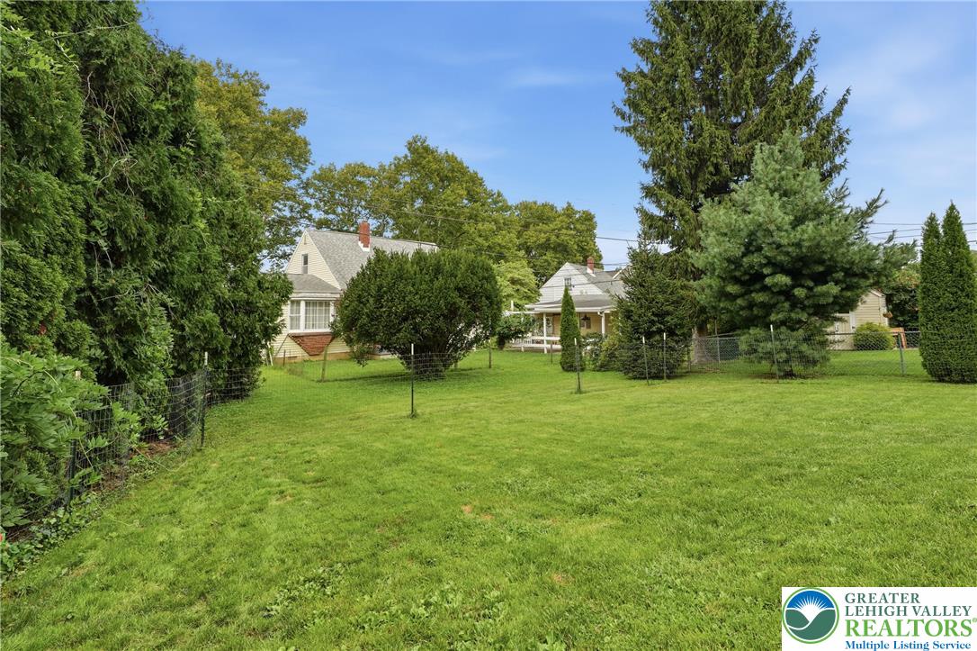 408 Maple Road Hellertown, PA 18055 - Photo 50 of 66 Mature trees frame a spacious lawn, offering privacy and natural beauty.