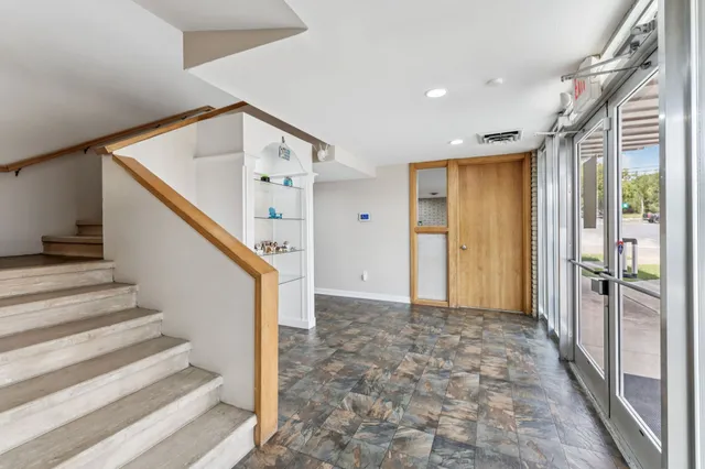 a view of an empty room with wooden floor