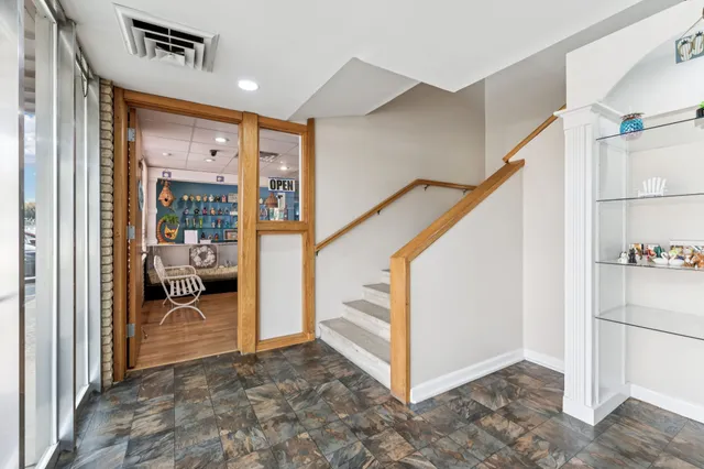 a view of a hallway with wooden floor and closet