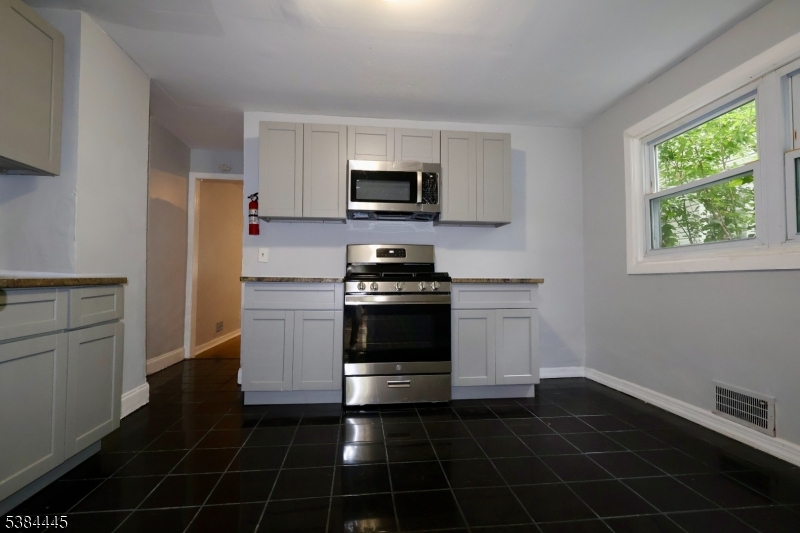 a kitchen with a stove a microwave and a sink