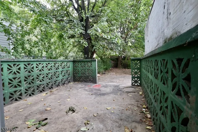 a view of a yard with plants and wooden fence
