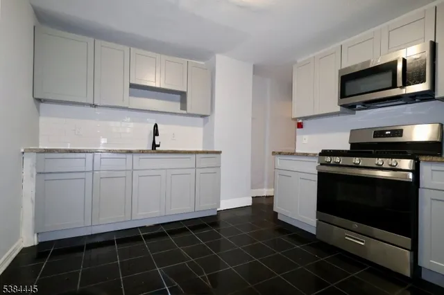 a kitchen with a sink stove and cabinets