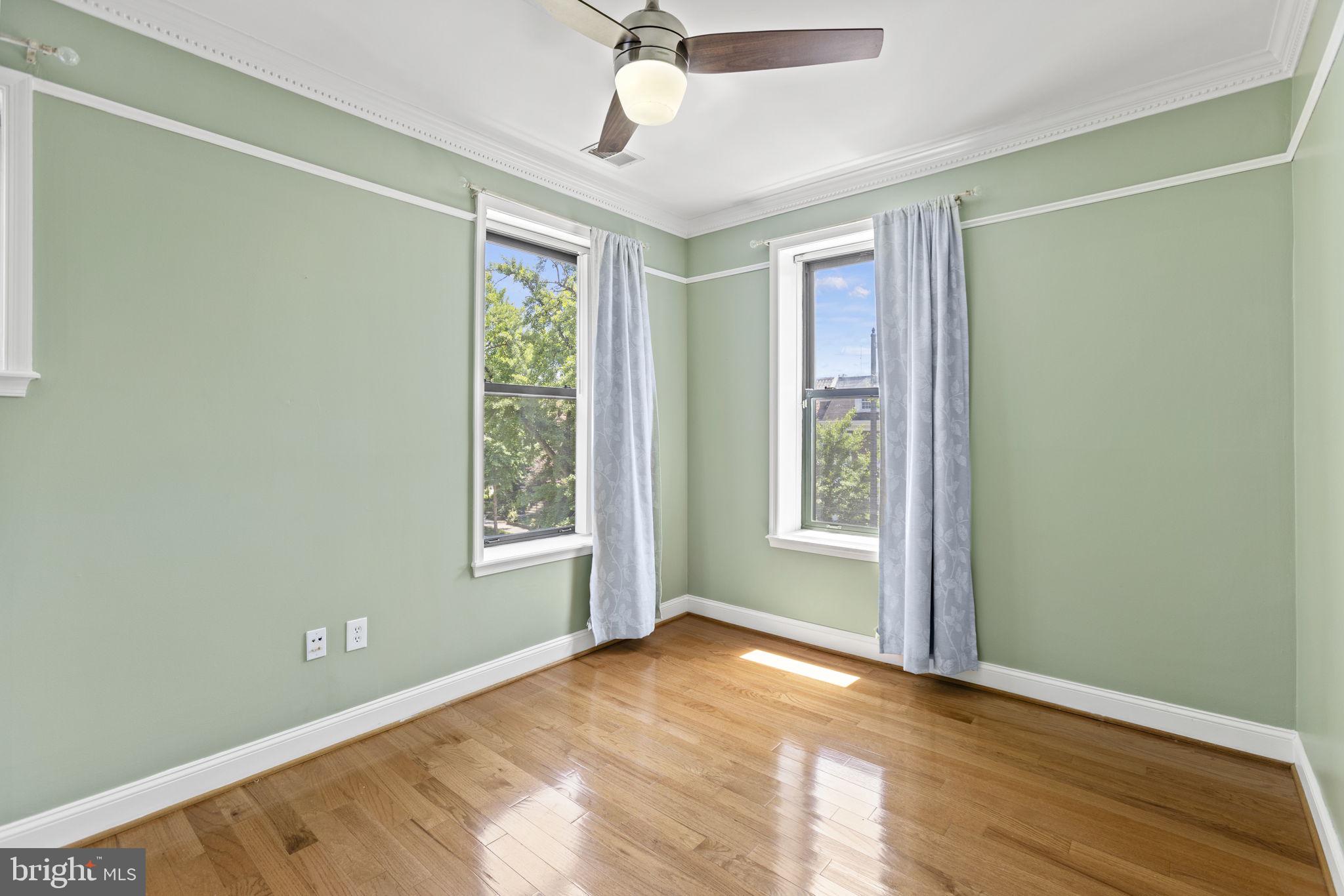 1437 Spring Road Northwest, Unit 21 Washington, DC 20010 - Photo 13 of 25 a view of an empty room with a window and wooden floor