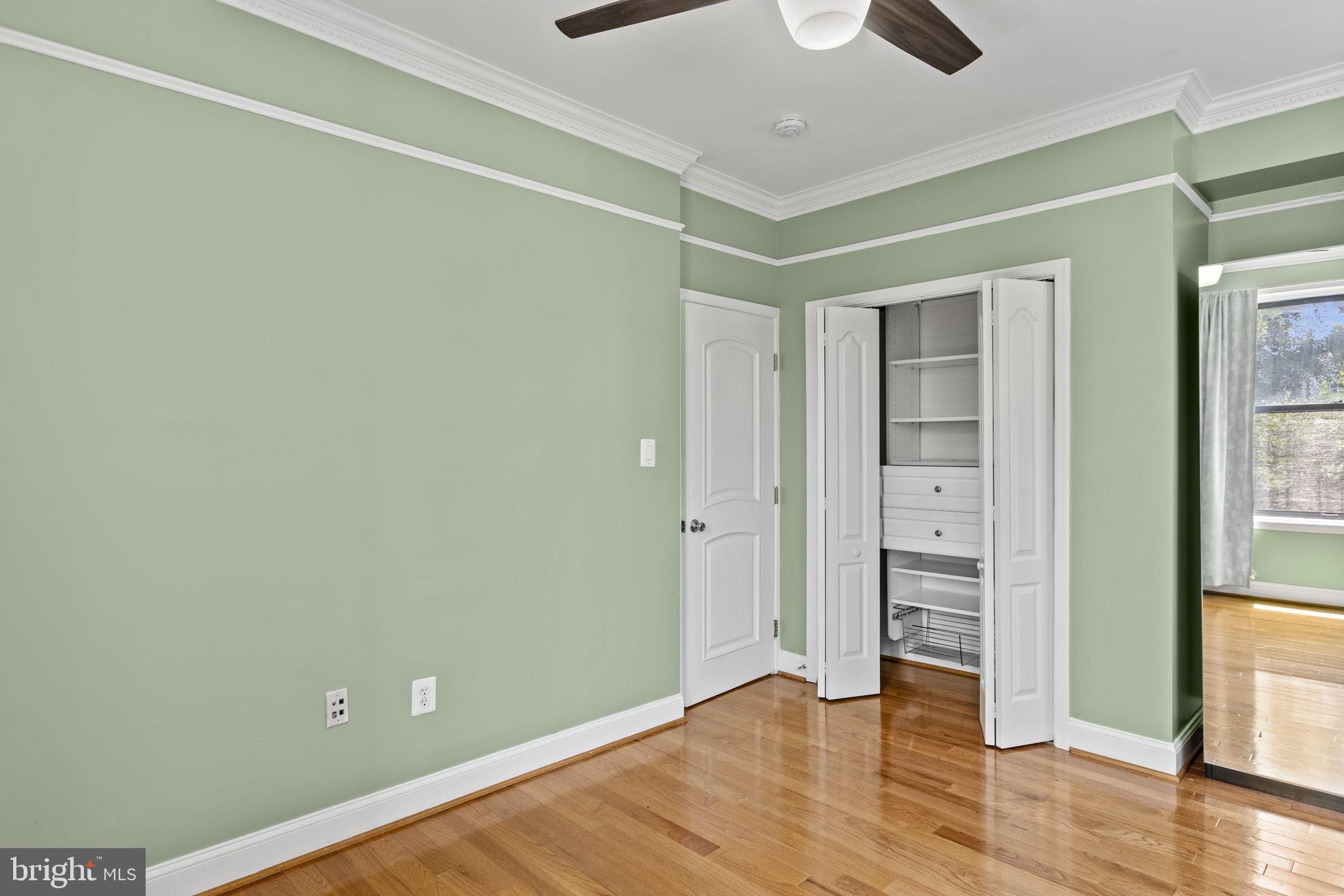 1437 Spring Road Northwest, Unit 21 Washington, DC 20010 - Photo 14 of 25 an empty room with wooden floor closet and windows