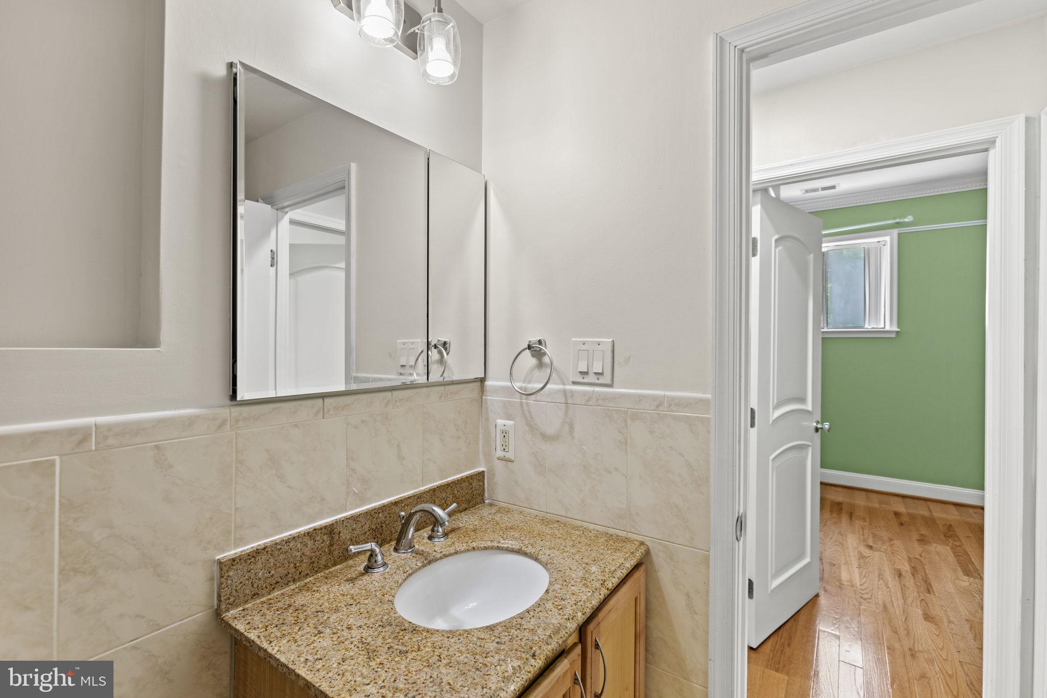 1437 Spring Road Northwest, Unit 21 Washington, DC 20010 - Photo 18 of 25 a bathroom with a sink and a mirror