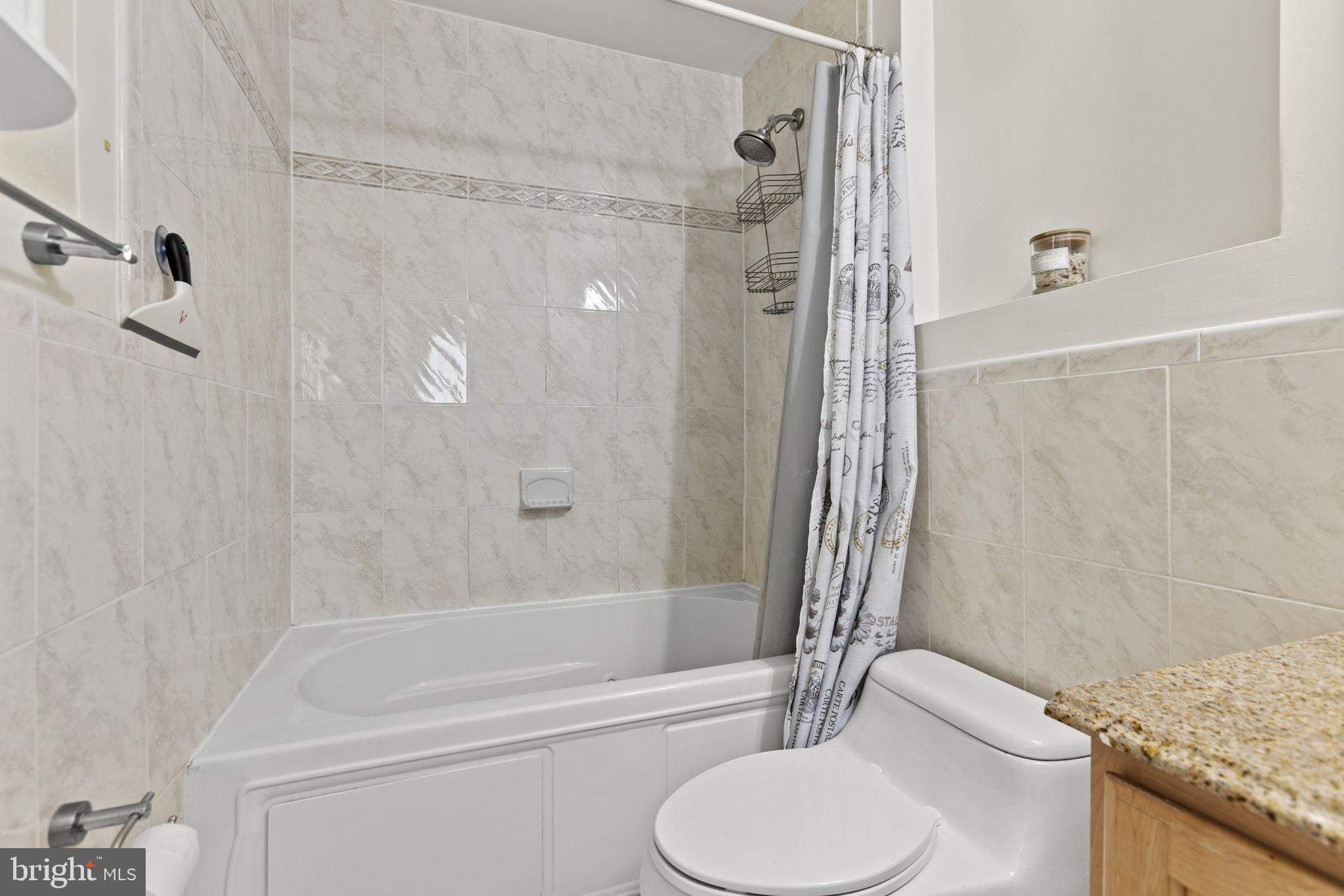 1437 Spring Road Northwest, Unit 21 Washington, DC 20010 - Photo 19 of 25 a bathroom with a granite countertop toilet sink and shower