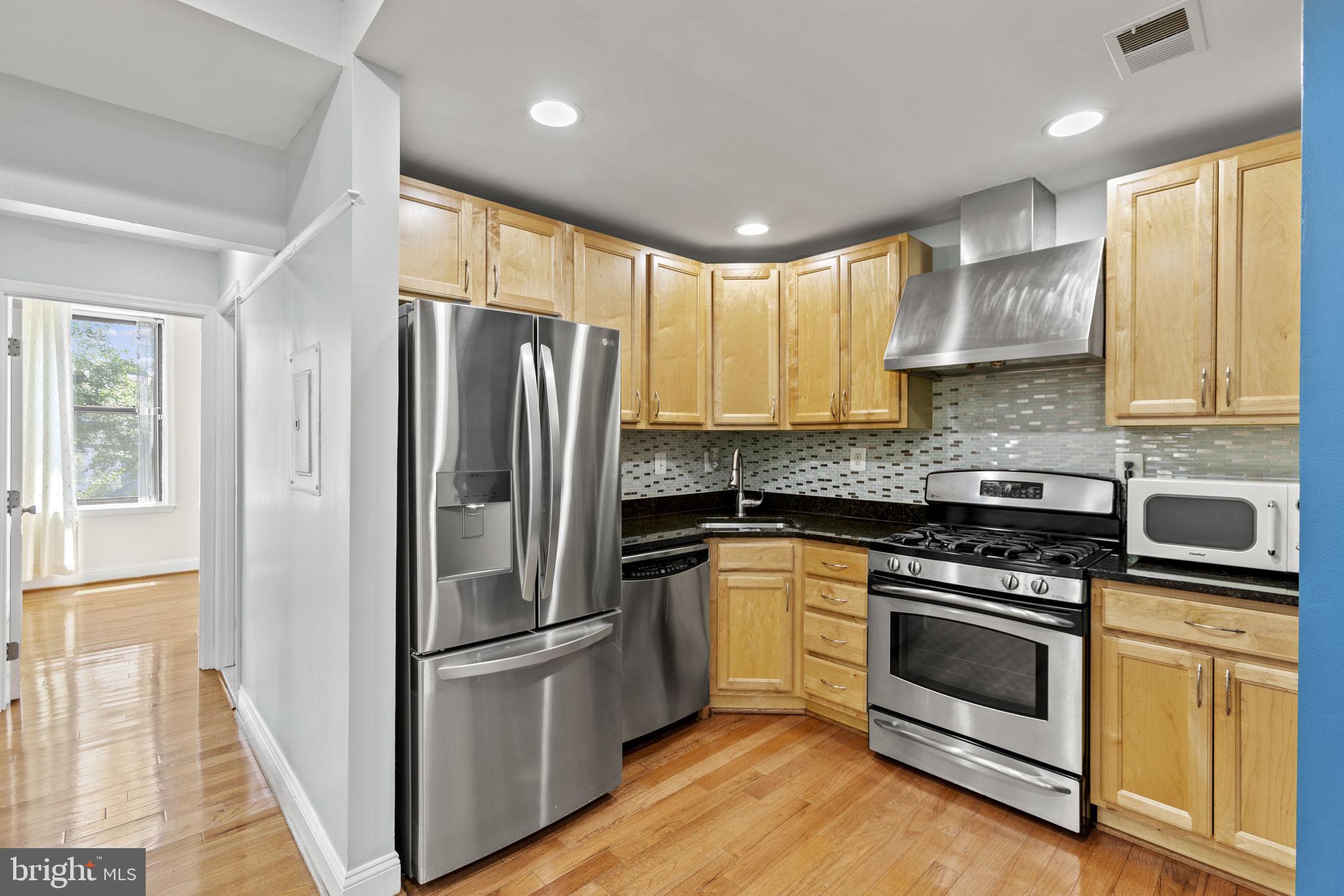 1437 Spring Road Northwest, Unit 21 Washington, DC 20010 - Photo 5 of 25 a kitchen with a stove a refrigerator and a sink